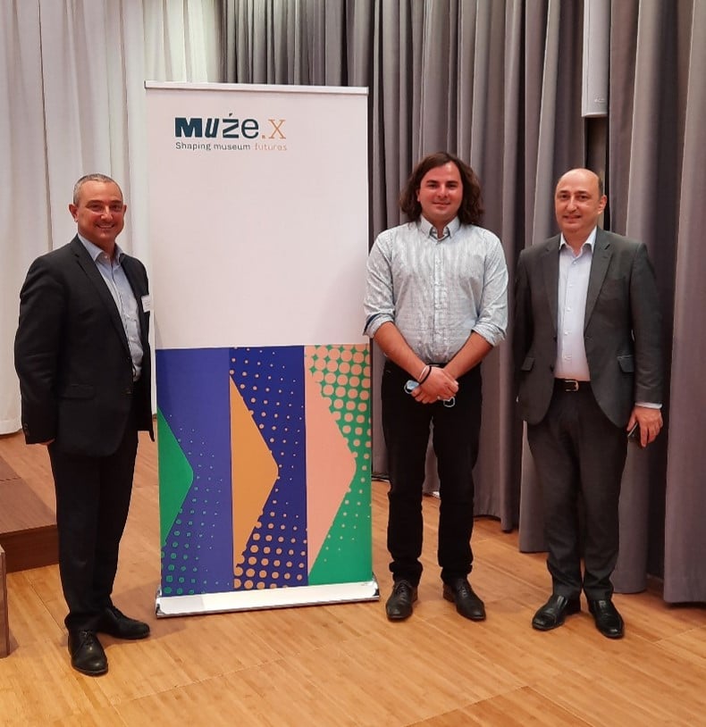 Ioan stands in the centre with two conference delegates