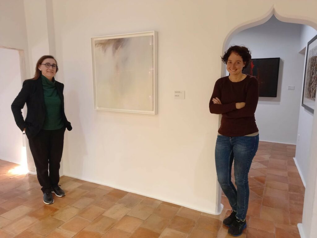 CELINA QUINTAS (LEFT) AND MERCEDES PORTERO (RIGHT) AT MUSEO DE ARTE ABSTRACTO ESPANOL, CUENCA, WITH THE LAST PAINTING BY ZOBEL ENTITLED “EL PUENTE” (OLEO Y PASTEL SOBRE LIENZO, 1984).