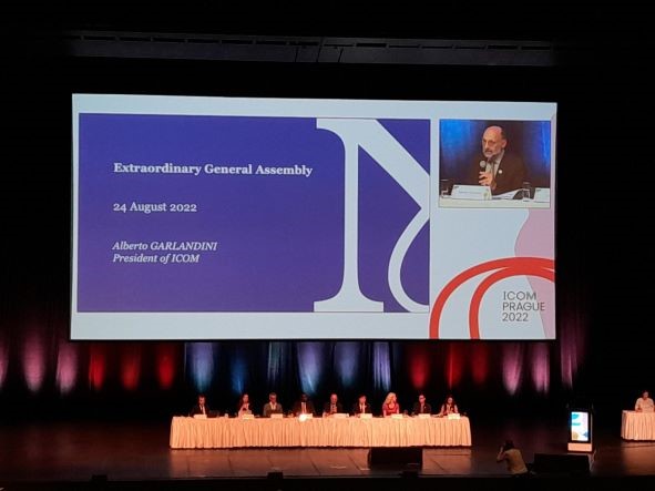 Photo of a lecture hall stage showing a panel discussion from ICOM conference 2022