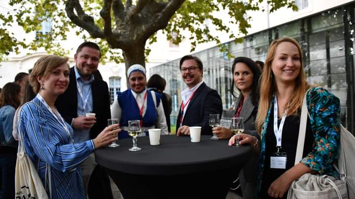 Marwa stands around a table with conference colleagues.