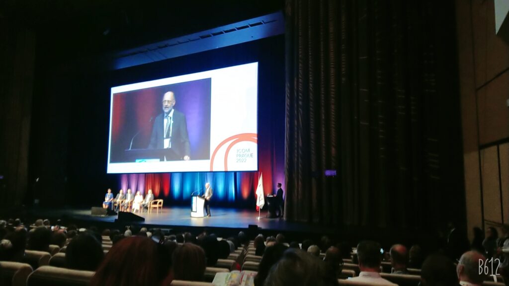 ICOM president giving a speech on stage.