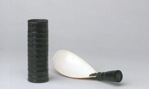Composite ladle in the form of a shallow shell bowl and a horn handle.