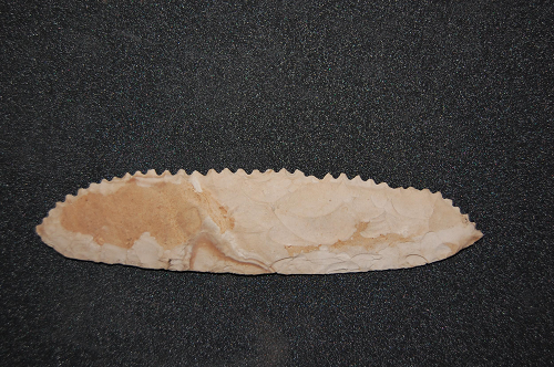 Flint sickle blade, pointed both ends; one serrated edge.