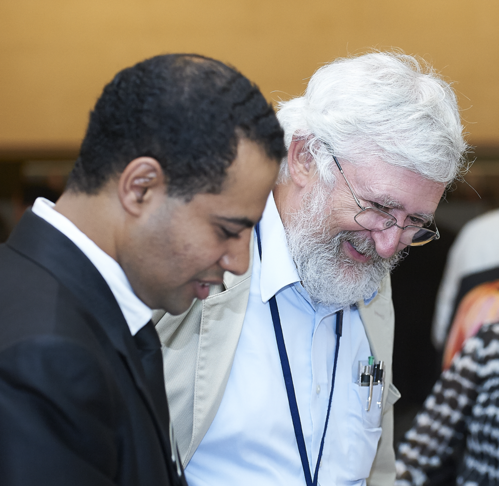 Close up of Mohamed Ahmed standing next to a colleague. Both men are looking down at something out frame.