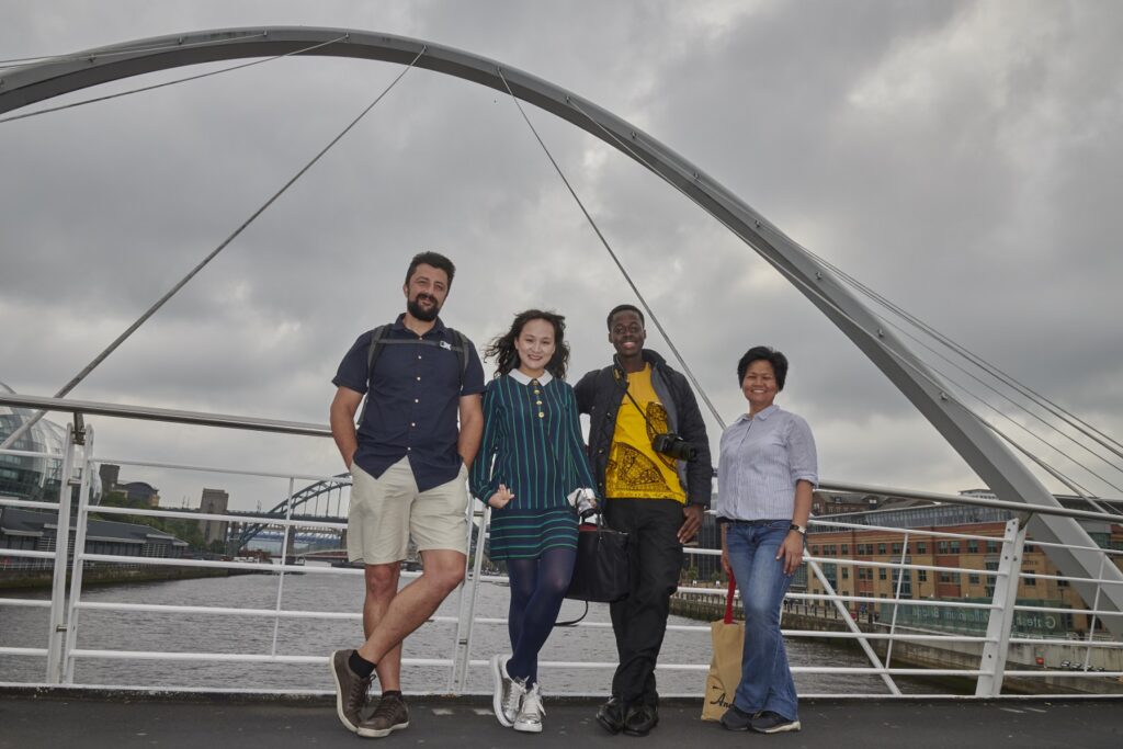 Ciprian standing next to three ITP colleagues on a bridge in Newcastle