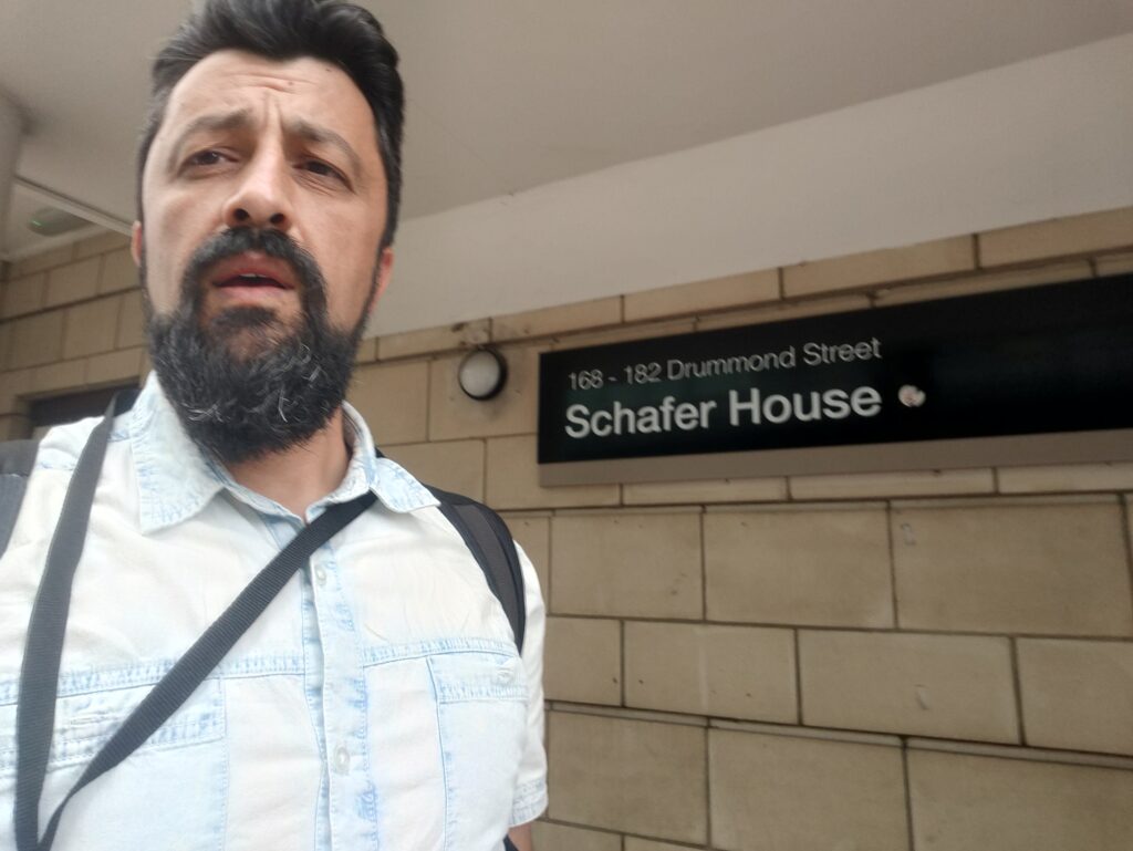 Ciprian taking a selfie in front of the entrance to Schafer House, UCL accommodation used during the International Training Programme