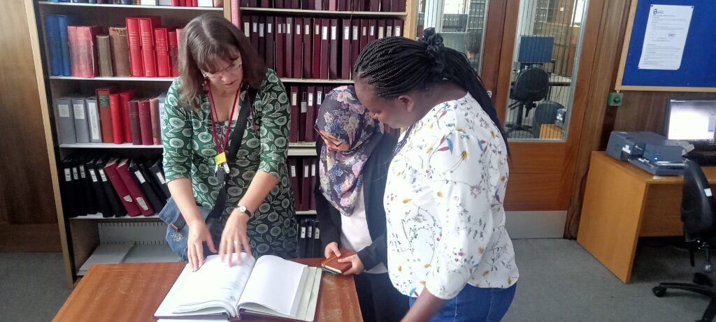 Archivist Rachael Gill displaying a hospital record dating 1700 to Malissa and Rodah.