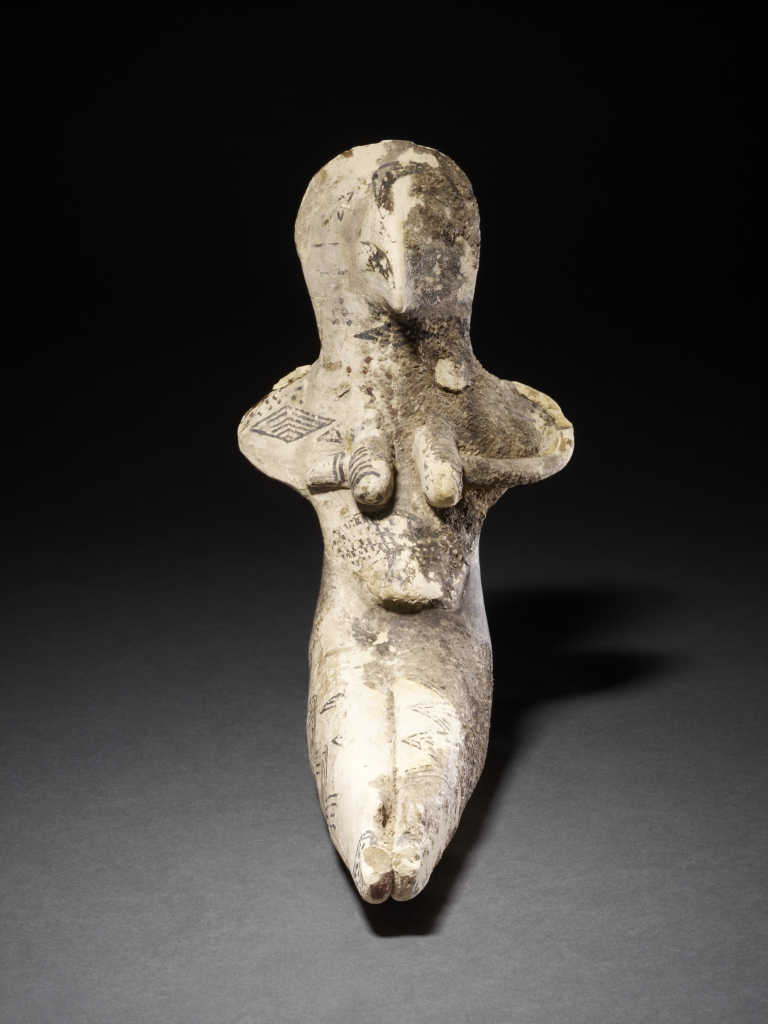 Ceramic female figure in a seated position. Black painted geometric decoration, green paint around eyes, red paint at neck.