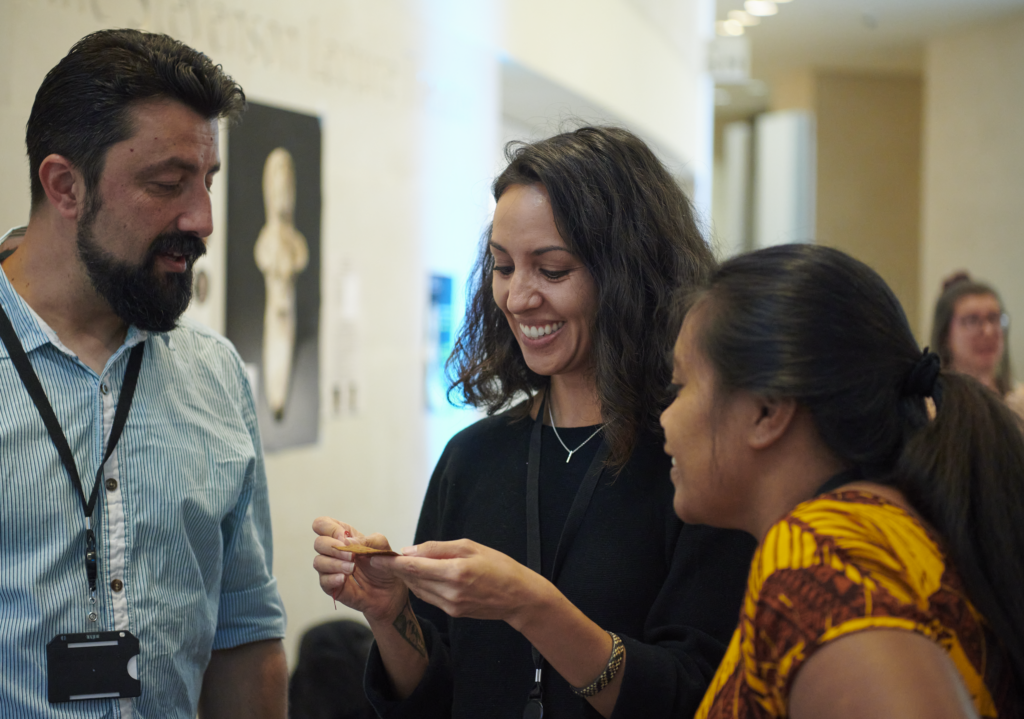 ITP fellow Kayla Annen showing part of display to colleagues Ciprian Dobra and Kirikara Koraua