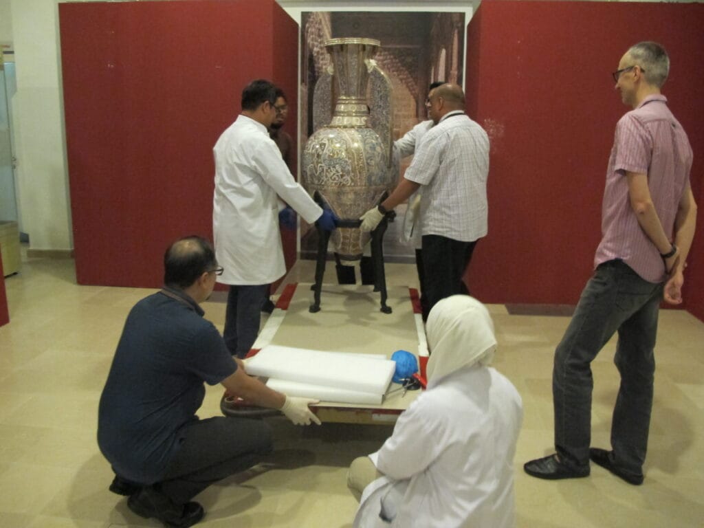 Staff at the Islamic Arts Museum de-installing the exhibition.