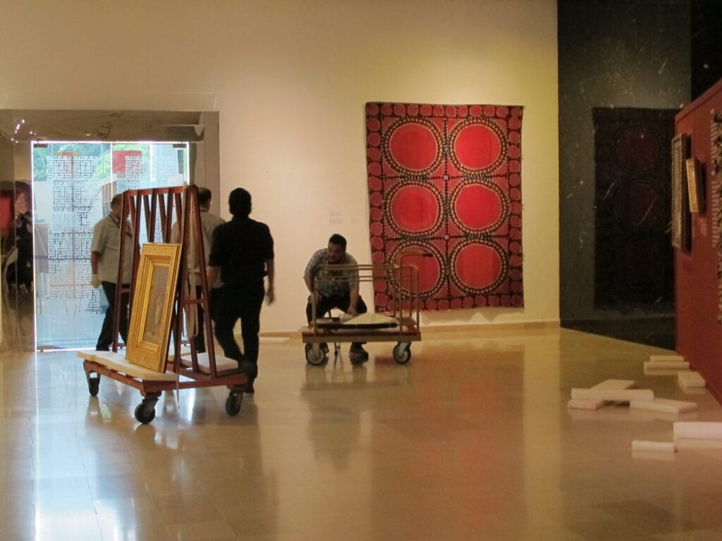 Staff at the Islamic Arts Museum de-installing the exhibition.