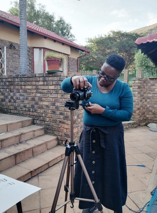 ITP fellow looking at a camera on a tripod.