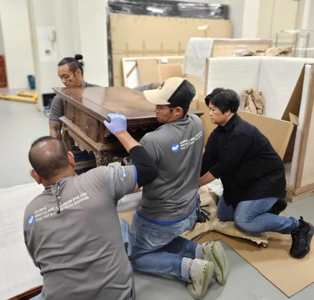 Photograph of four people moving an object.