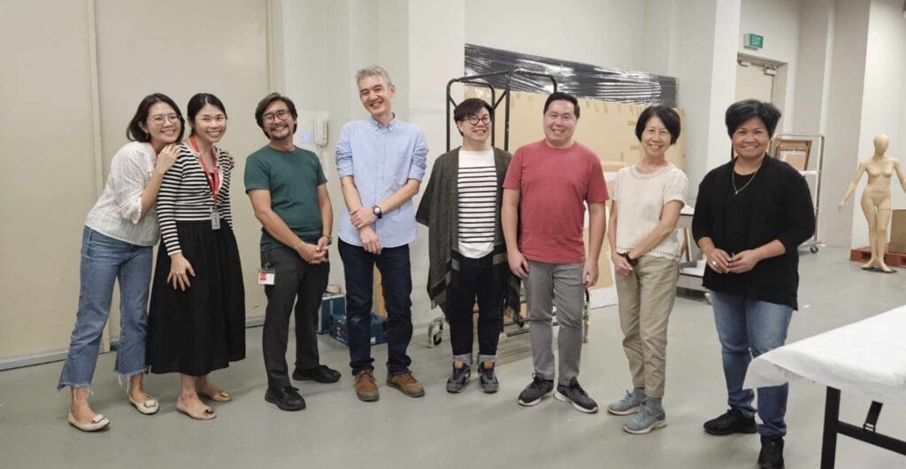 8 people standing in a line, smiling.