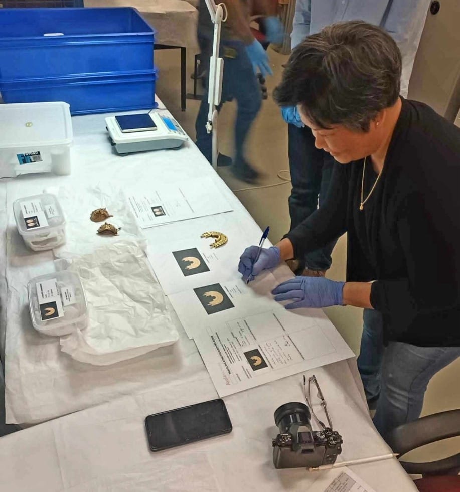 Photograph of Aprille completing condition checks on objects.