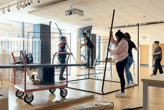 Students constructing a metal display frame.