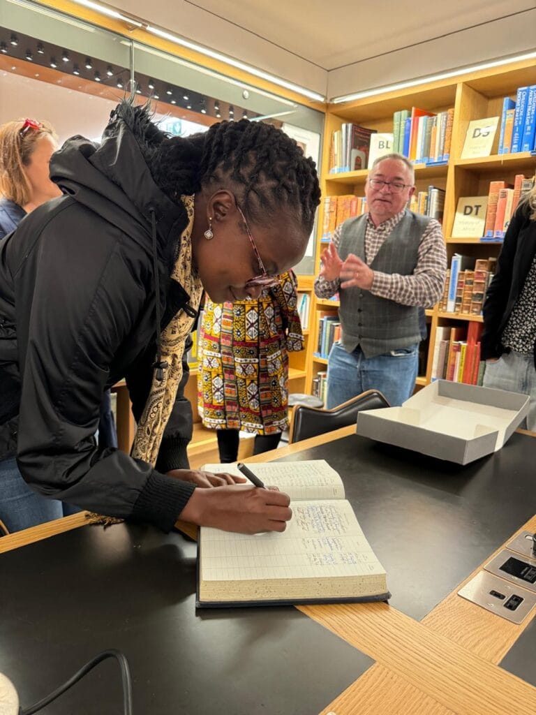 Photograph of a woman writing in a book.