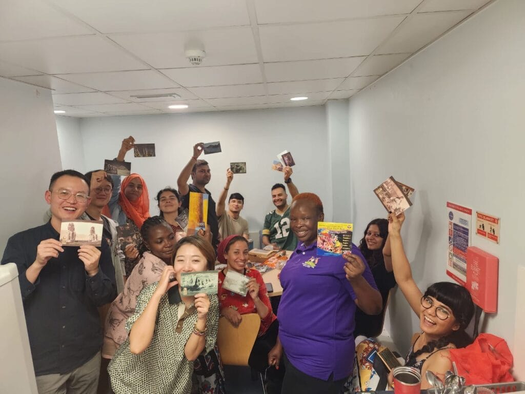 Photograph of a group of people, each holding a postcard towards the camera