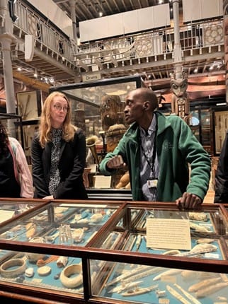 Photograph of people looking in a display case.