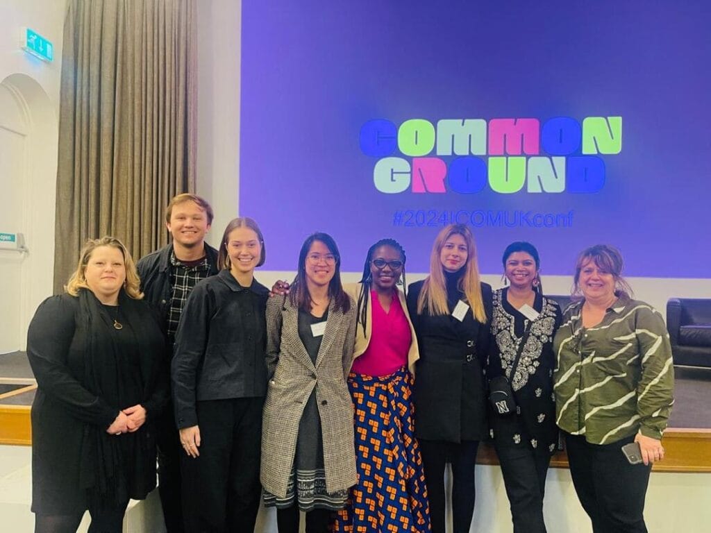 Group photo in front of a projection saying 'common ground'