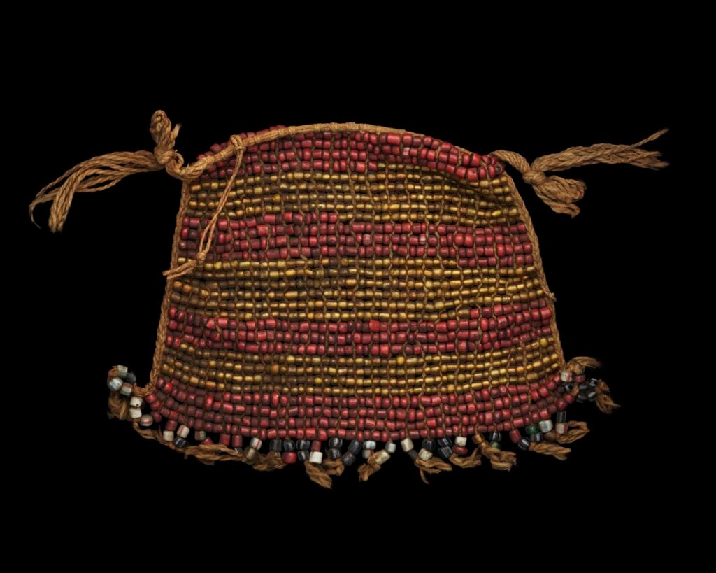 Apron made yellow and red glass beads in stripe design; woven with cotton thread; multicolored beaded fringe.